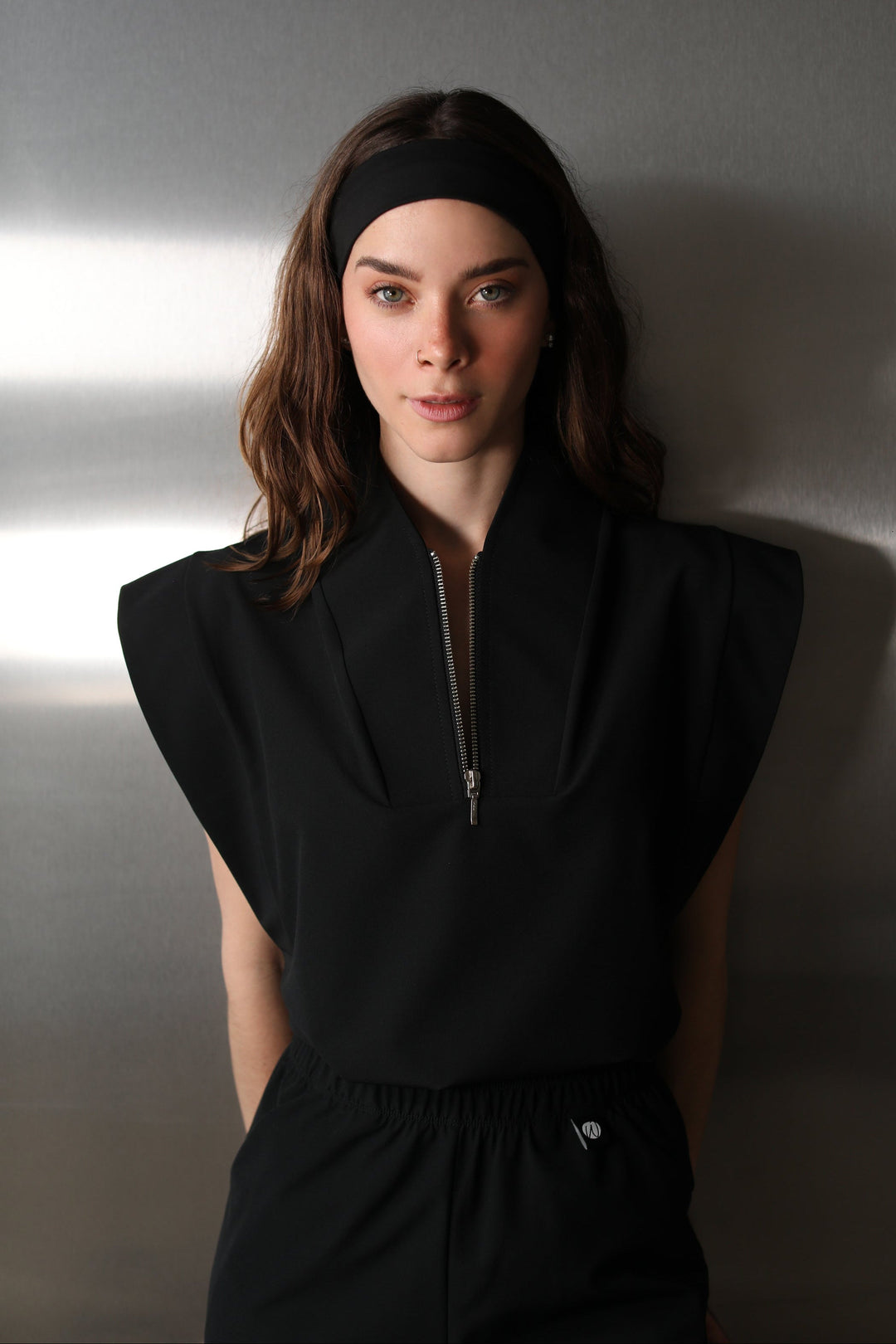 Front view of woman wearing Black Chill Band styled with black scrubs