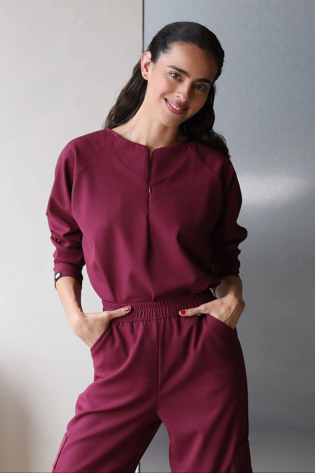 Model wearing Fall Burgundy Scrub Top with matching scrub pants