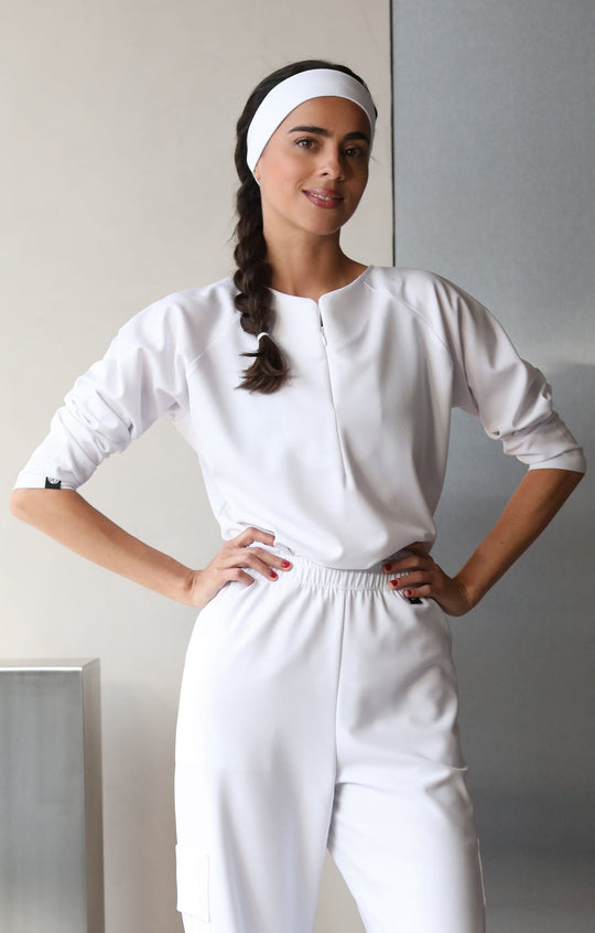 Model wearing Fall Crystal White Scrub Top with matching scrub pants