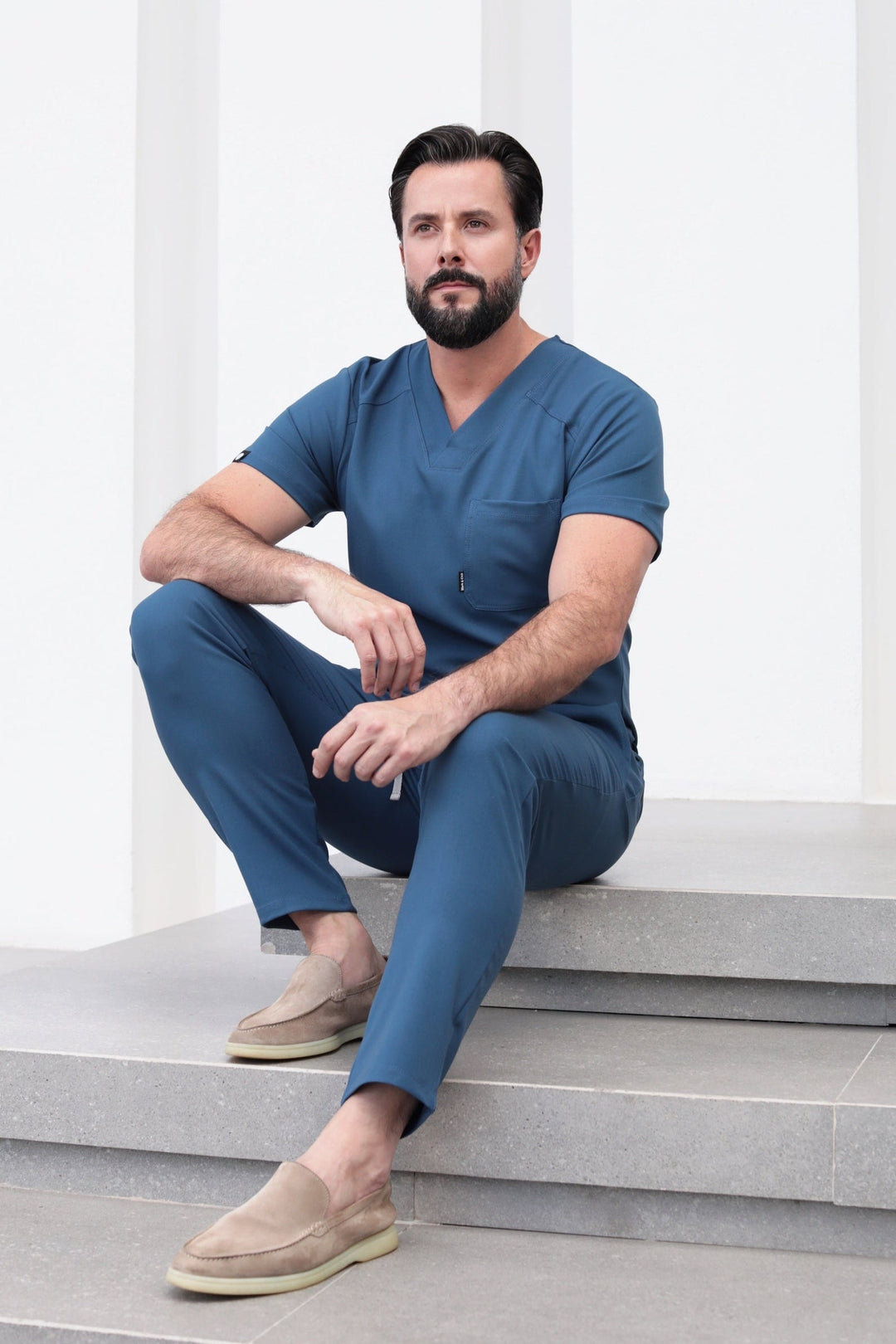 Man wearing Fresh Indigo Scrub Pants in a seated position showing the comfortable fit