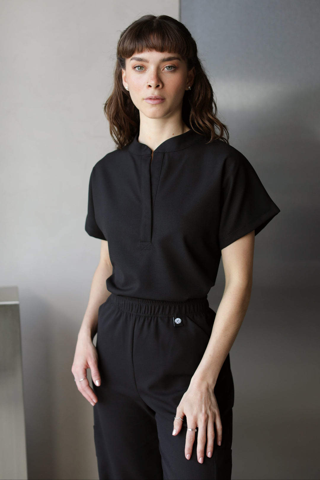 Woman wearing Glam Black Scrub Top by Work & Chill