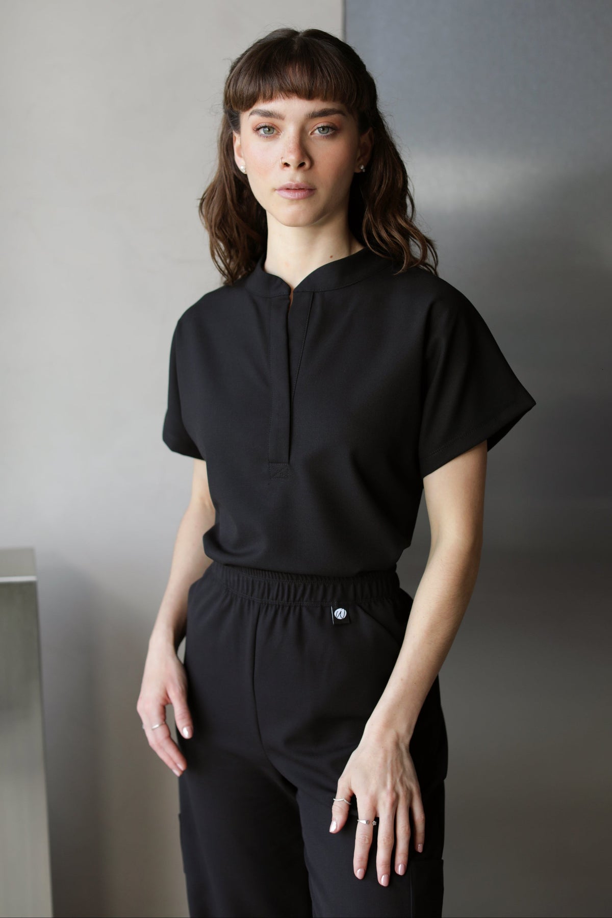 Woman wearing Glam Black Scrub Top by Work & Chill