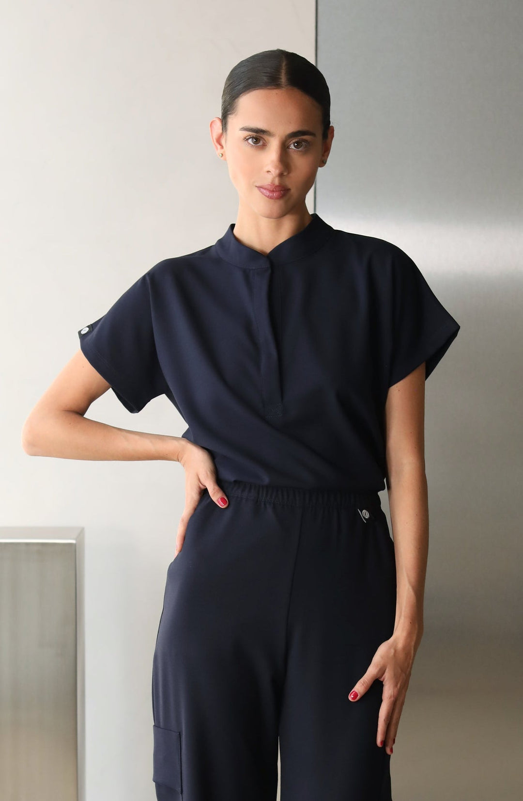 Model wearing Glam Navy Scrub Top with matching scrub pants
