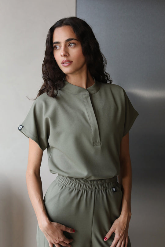 Woman wearing Glam Olive Scrub Top by Work &amp; Chill