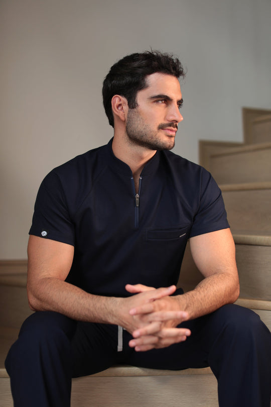 Man wearing Harry Navy Scrub Top in a seated position
