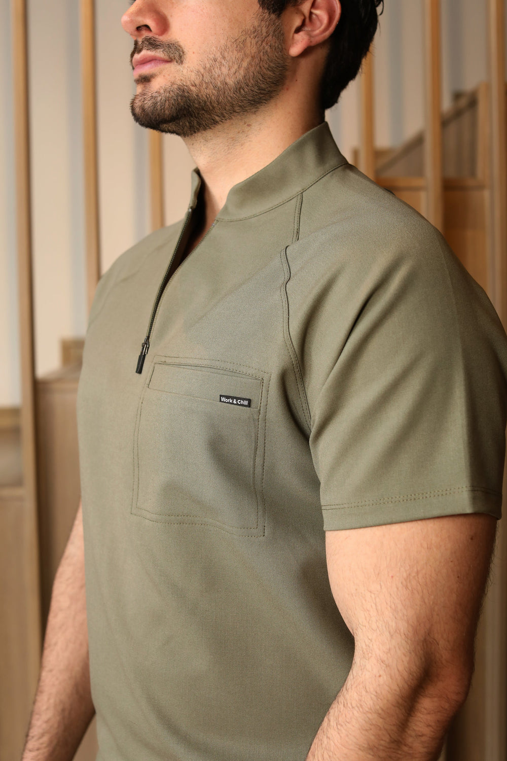 Close-up of Harry Olive Scrub Top showing the structured collar and front zipper.