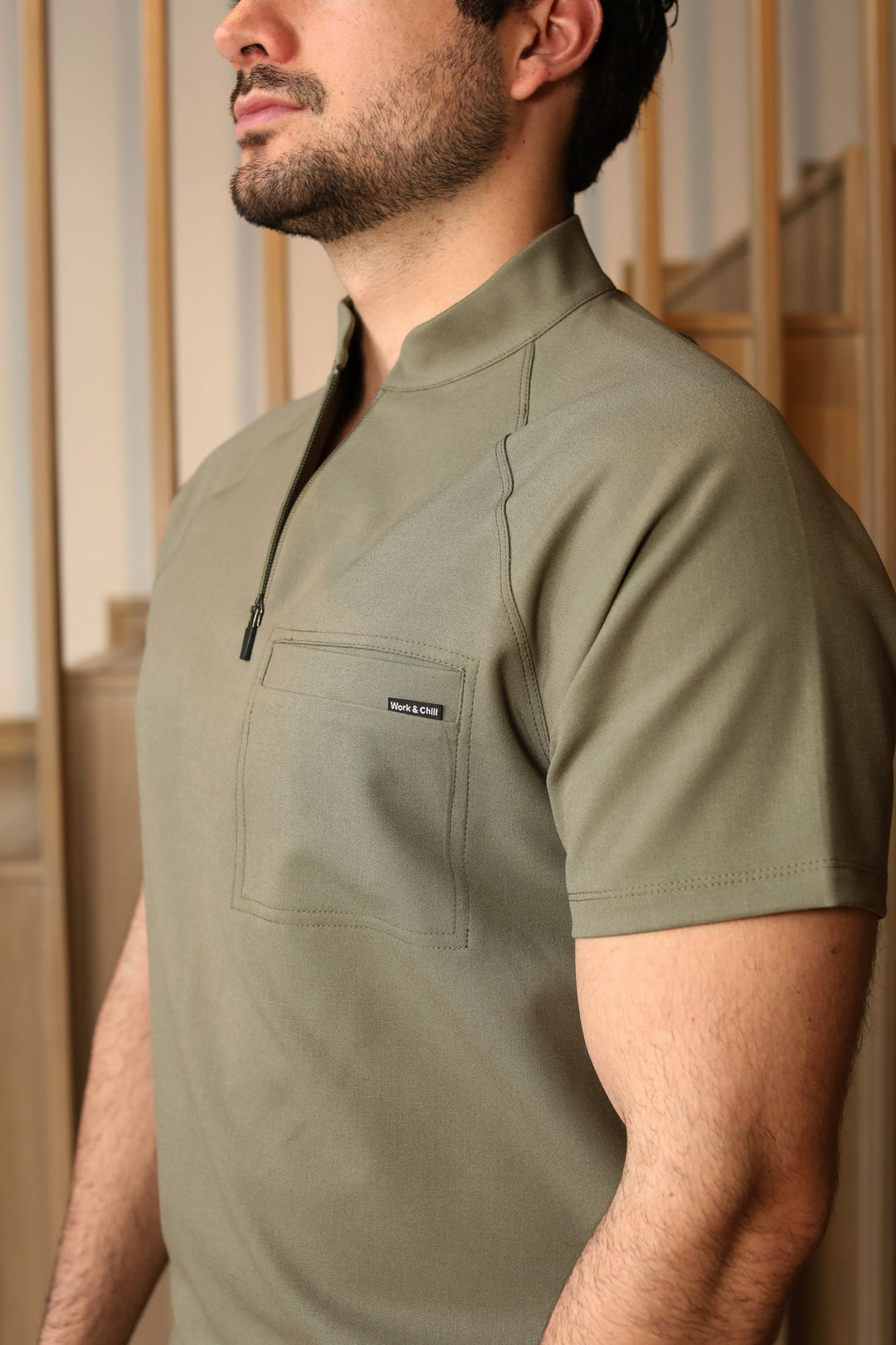 Close-up of Harry Olive Scrub Top showing the structured collar and front zipper.