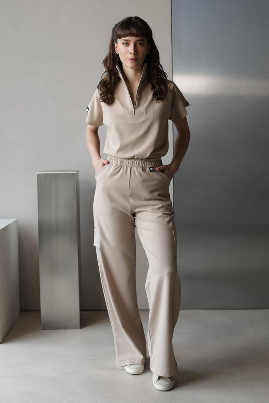 Model wearing Victory Natural Scrub Top with matching scrub pants