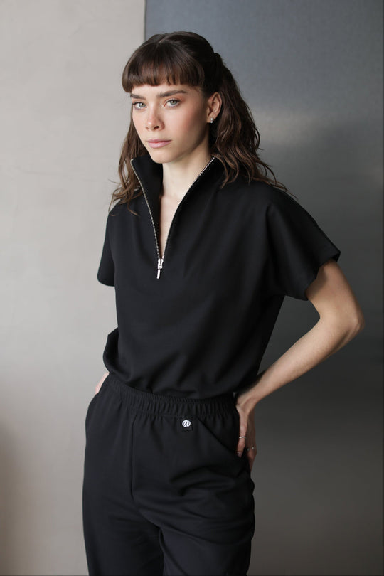 Woman wearing Victory Black Scrub Top by Work &amp; Chill