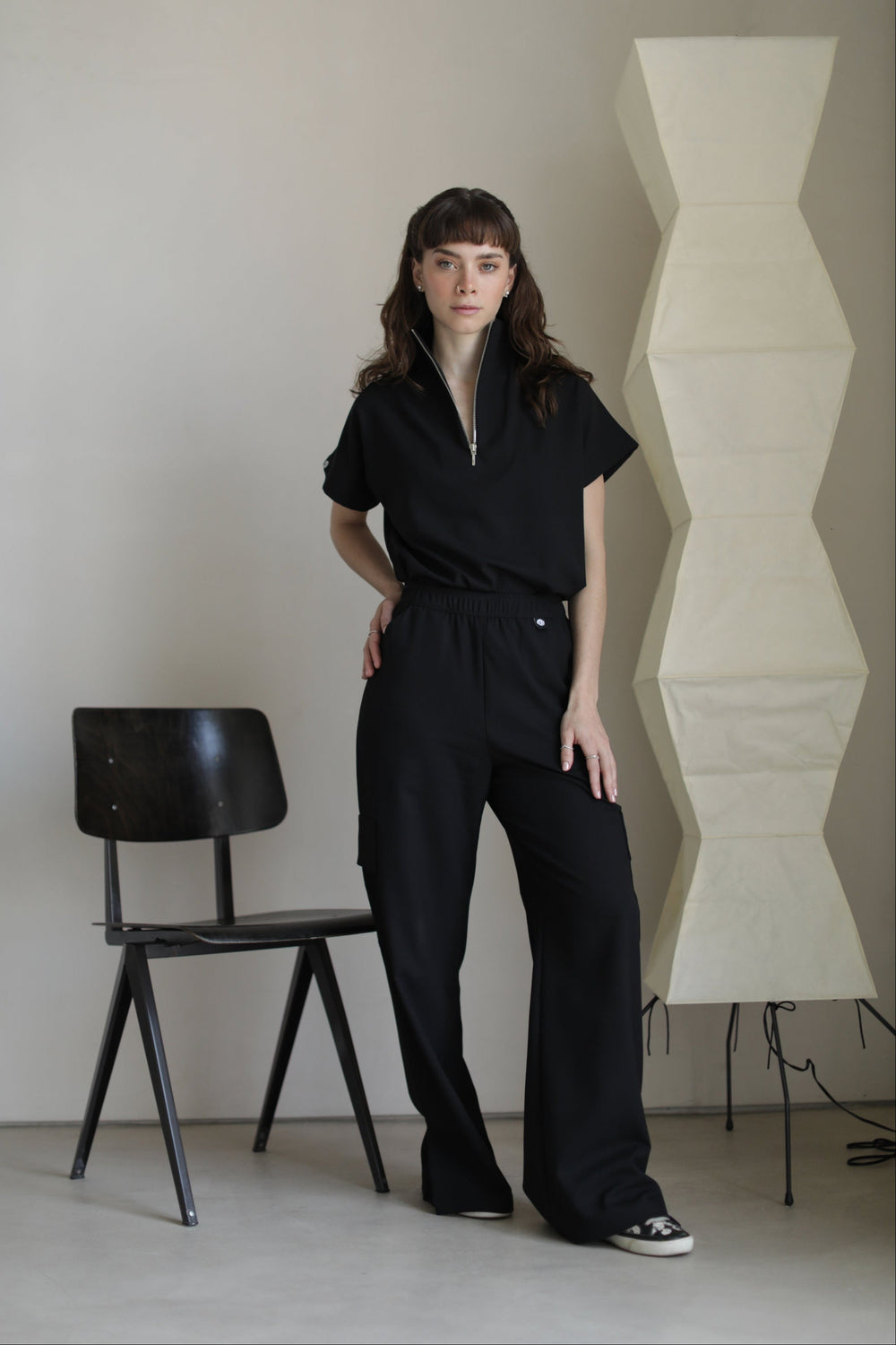 Model wearing Victory Black Scrub Top with matching scrub pants