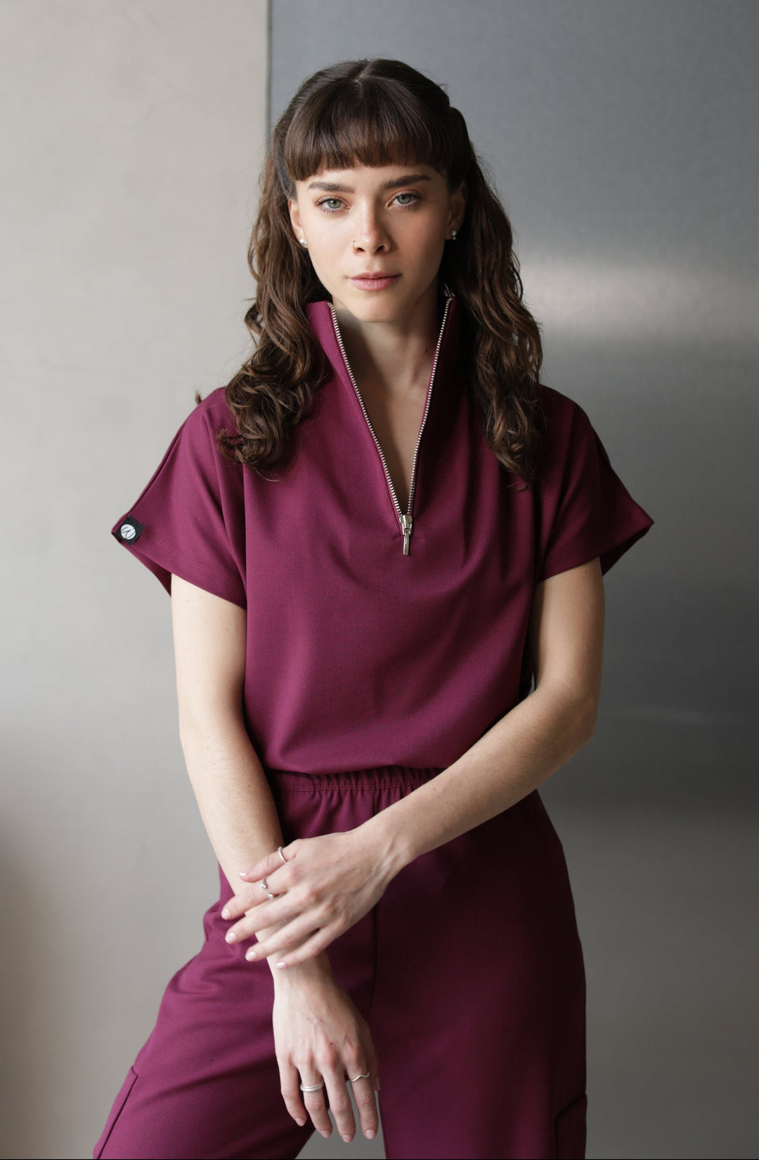 Woman wearing Victory Burgundy Scrub Top by Work & Chill