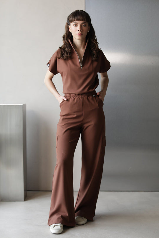 Model wearing Victory Cocoa Scrub Top with matching scrub pants