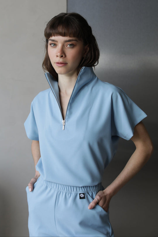 Woman wearing Victory Dream Blue Scrub Top by Work &amp; Chill
