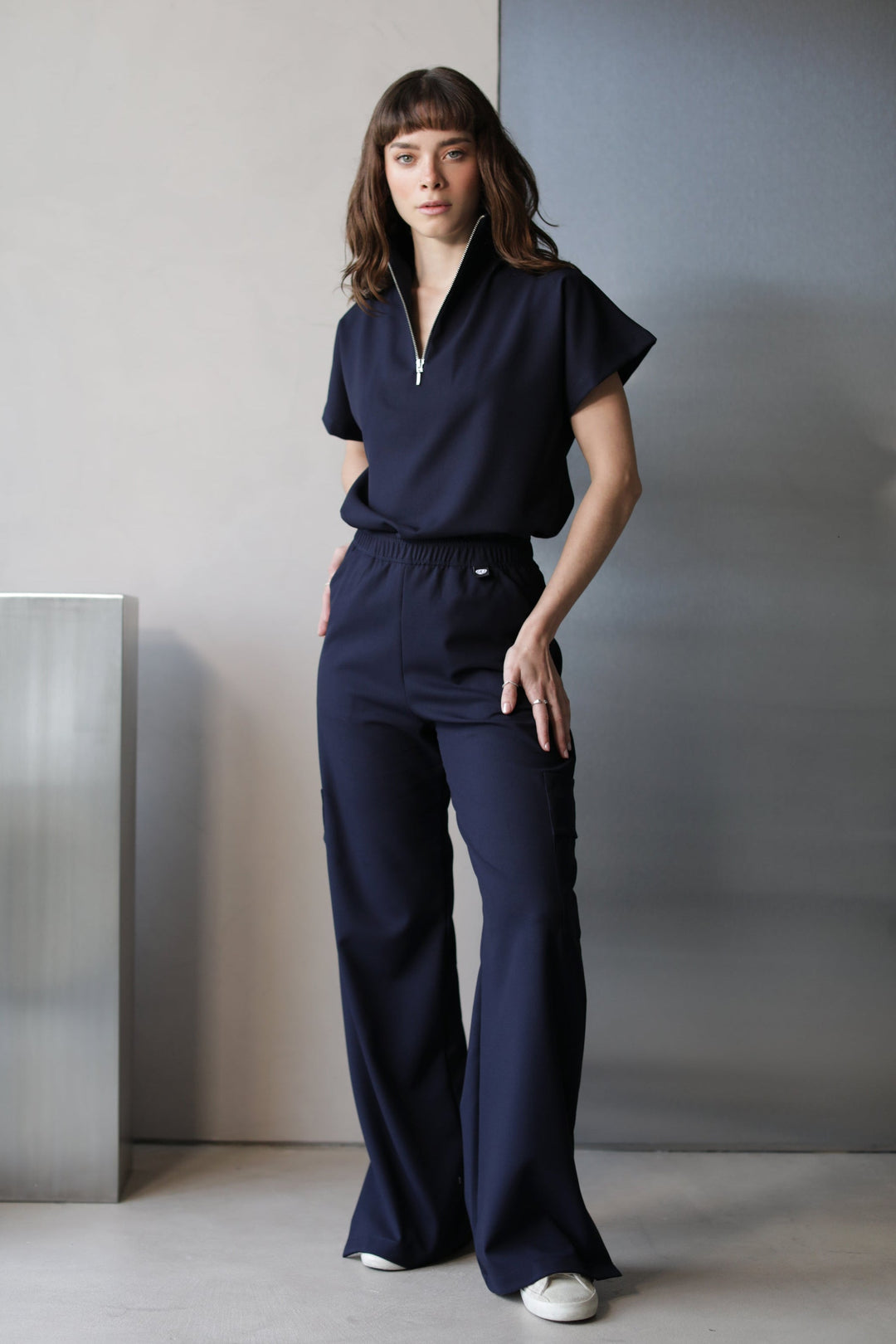 Model wearing Victory Navy Scrub Top with matching scrub pants