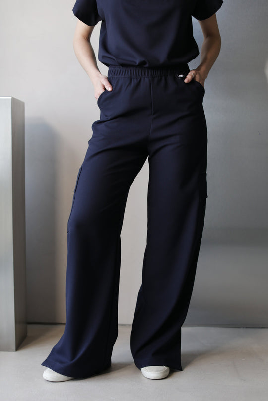 Full-length view of Victory Navy Scrub Top styled with matching scrub pants