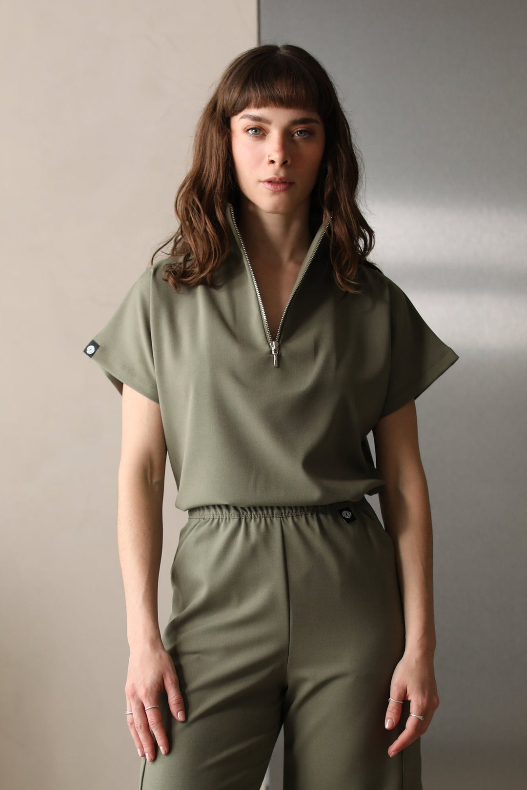 Woman wearing Victory Olive Scrub Top by Work & Chill