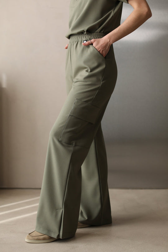 Side view of Victory Olive Scrub Top styled with matching scrub pants