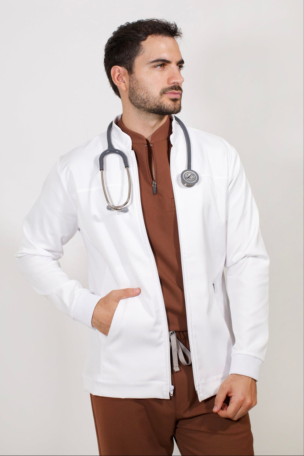 Healthcare professional wearing Men’s White Work Coat over Cocoa scrubs