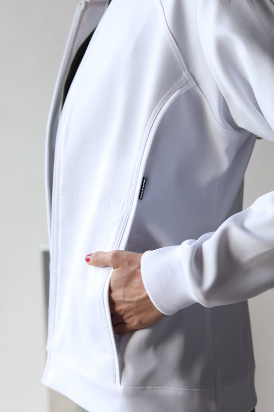 Healthcare professional wearing Women’s White Medic Coat over green scrubs